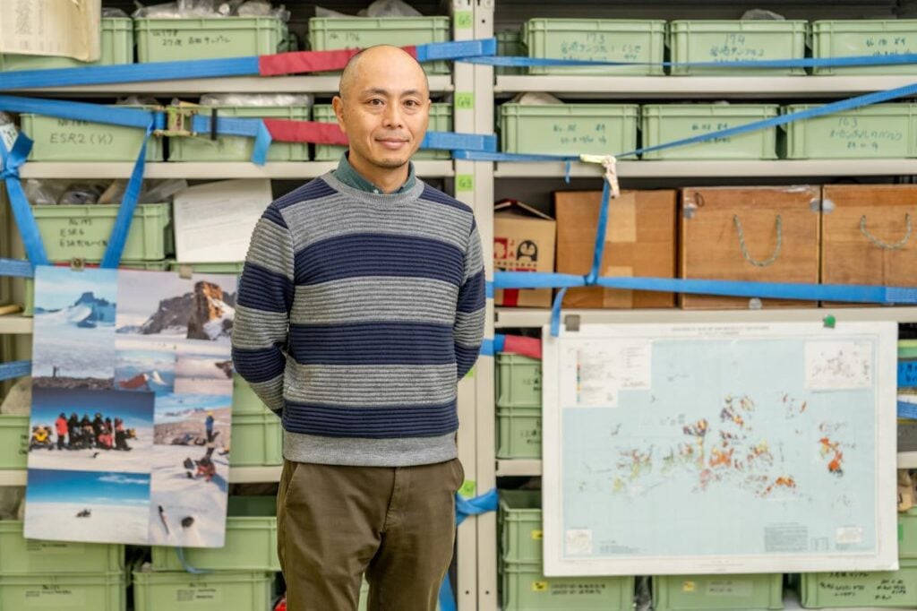 南極で収集したサンプルが収められている棚の前に立つ菅沼教授