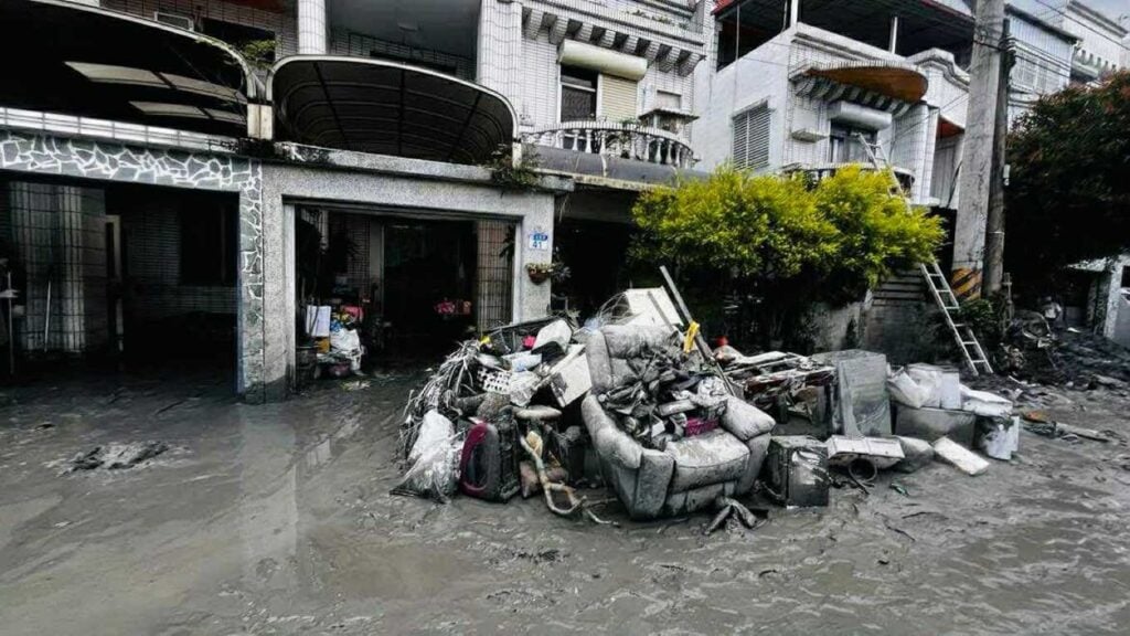 写真：台湾台風被害により、被災した家から運び出された濡れた家財道具などが道路に積み重なっている様子。