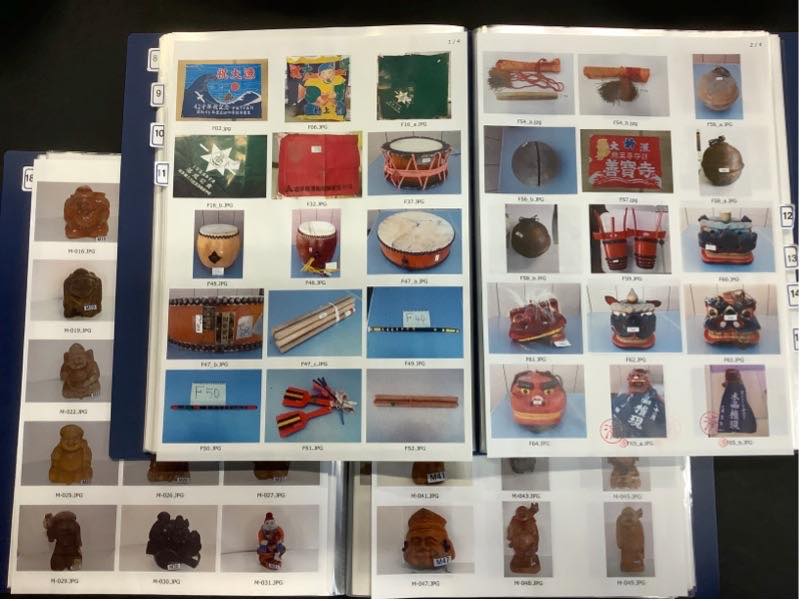 「思い出の品」のインデックスファイルの例。見開きには、大漁旗、太鼓、獅子舞のお面、木彫りの置物、笛など、写真以外の「物」が一つずつ整理番号と共に写真に収められている